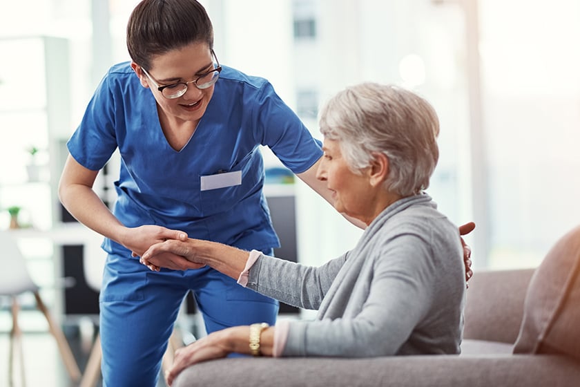 Care associate helping senior woman